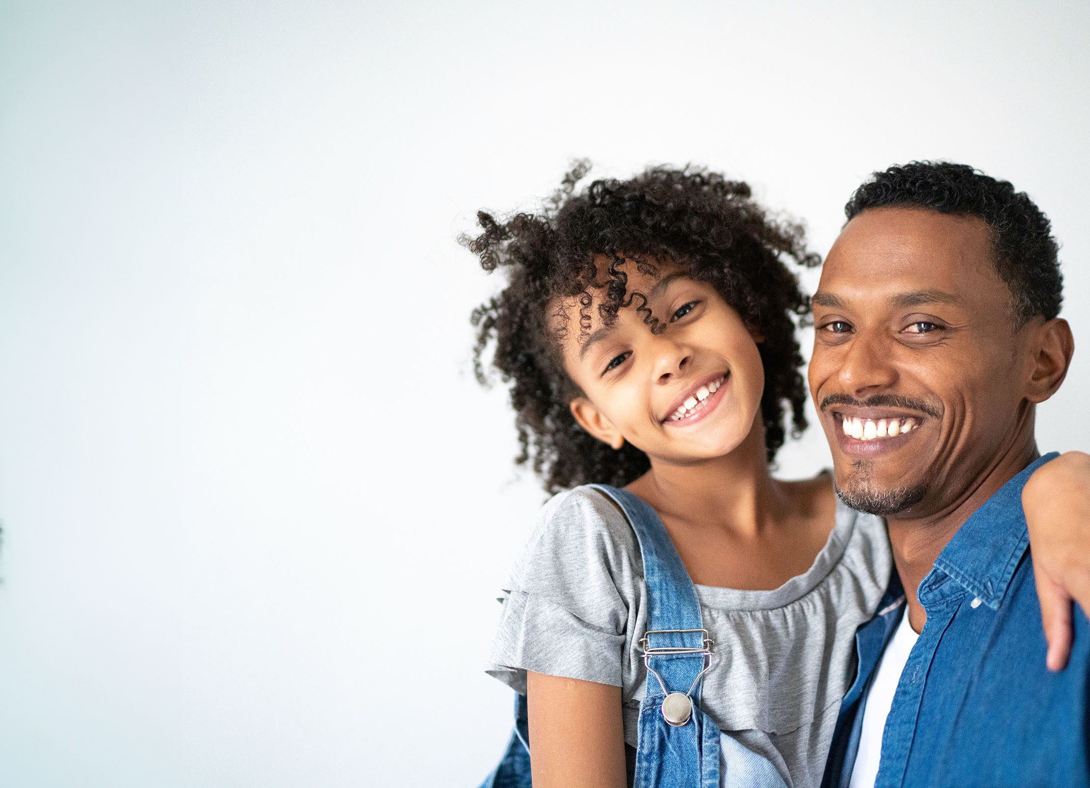 Father and daughter smile and hug