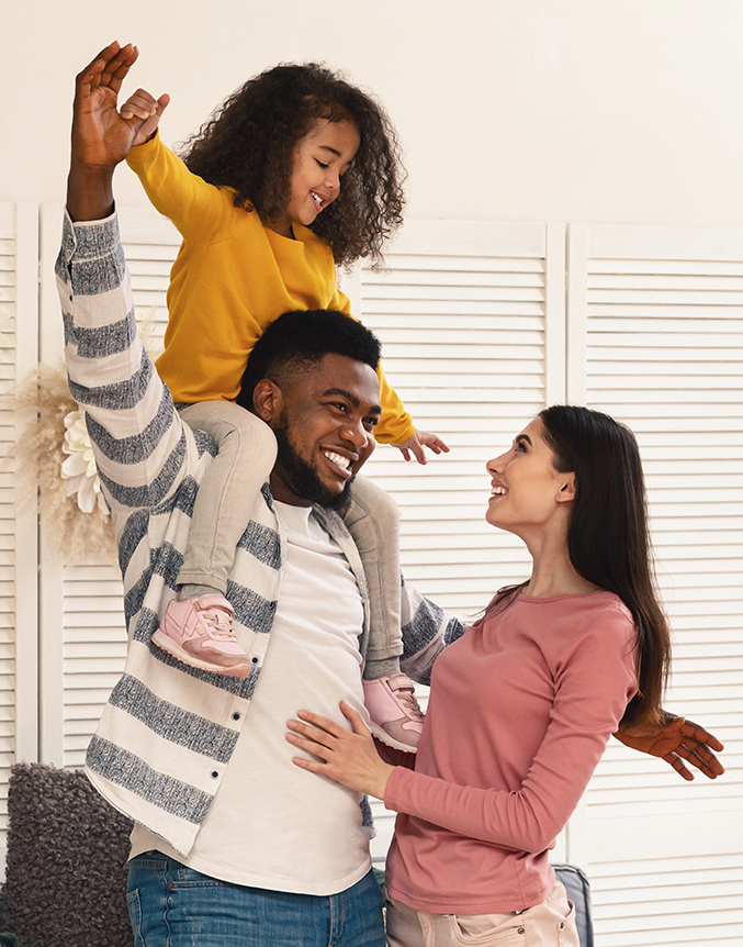 International family have fun. Father holds daughter on shoulders