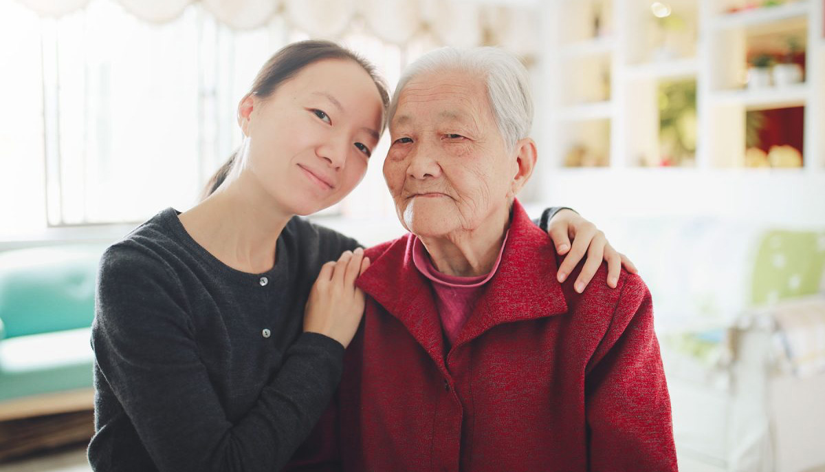 Grandmother and granddaughter embrace and smile